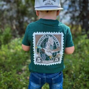 Child in green shirt and cap outdoors.