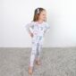 Child wearing bow-patterned pajamas smiling.