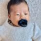 Baby with blue pacifier relaxing