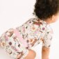 Baby in floral horse-print romper crawling