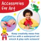 Child using art smock and safe scissors.