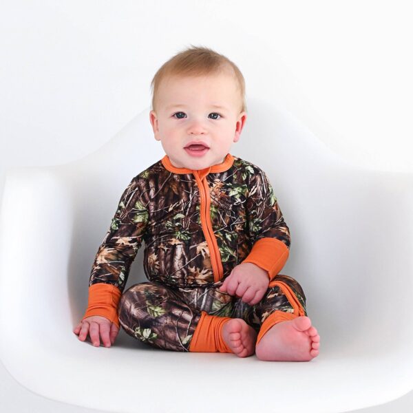 gigi and max hunter camo zip sleepies little bamboo baby outfit Baby in camouflage onesie on white chair.