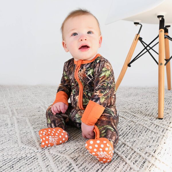 gigi and max hunter camo zip sleepies little bamboo baby outfit Baby in camo onesie sitting on carpet.
