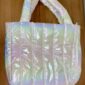 Iridescent puffy tote bag on wooden surface.