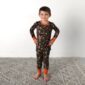 Child in camo pajamas on gray rug