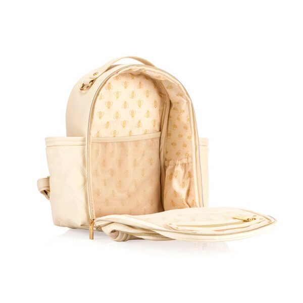 itzy ritzy milk & honey itzy mini plus™ diaper bag backpack Open cream backpack with bee pattern interior.