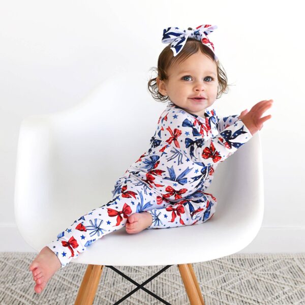 gigi and max eleanor bow clip bow 4th of july hair accessory Baby in starry pajamas on white chair.