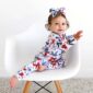 Baby in starry pajamas on white chair.