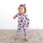 Baby in butterfly-patterned outfit with matching bow.