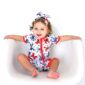 Baby wearing star-patterned romper and headband.
