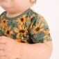 Baby wearing sunflower print shirt.