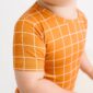 Baby in orange grid-patterned shirt, close-up.
