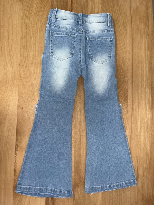 Blue flared jeans on wooden floor