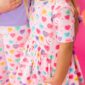 Children's heart-patterned clothing on pink background.