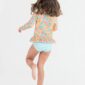 Girl wearing floral swimsuit and striped bottoms.
