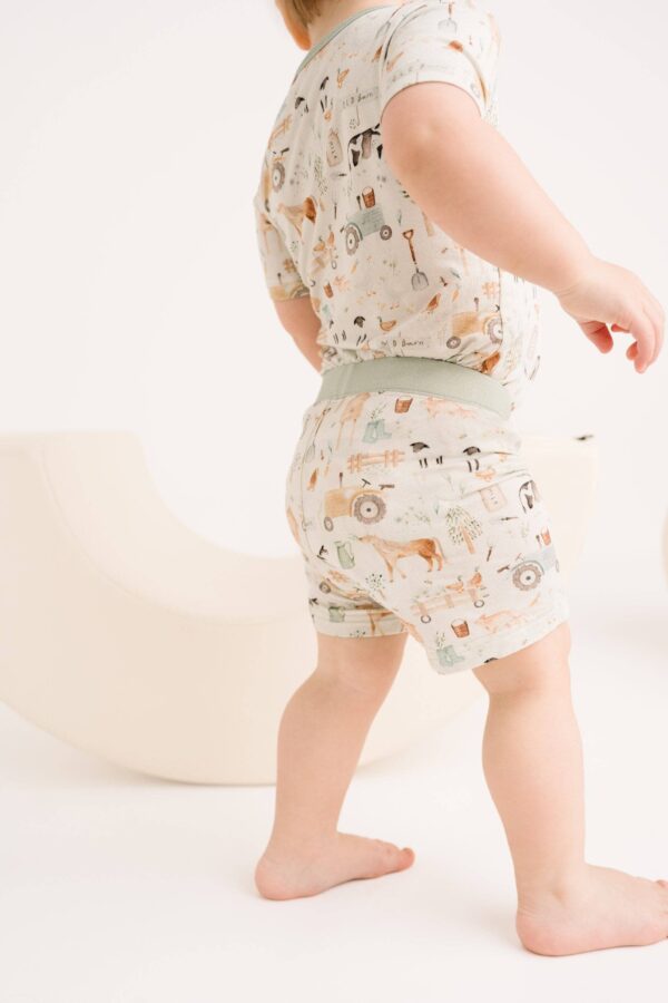 little one shop little farm bamboo shorts set Toddler wearing patterned outfit, walking indoors.