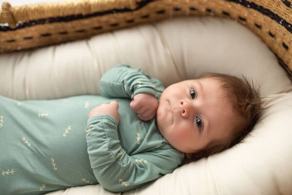 three little tots arrow print knotted newborn baby gown pajamas Baby in green outfit lying in crib