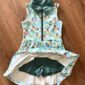 Colorful sleeveless golf dress on wooden floor.