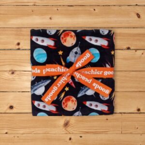 Space-themed cloth with orange ribbon on wood surface.