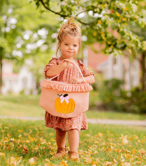 bits & bows halloween ruffled pumpkin tote Child holding pumpkin basket in autumn leaves.
