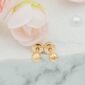 Gold stud earrings on marble with pink flowers.