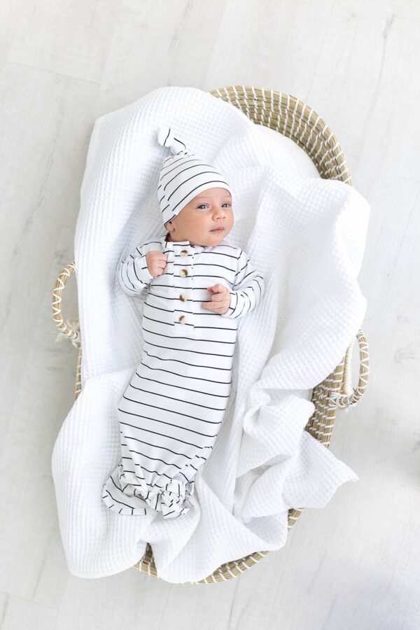 Baby in striped outfit lying in basket
