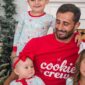 Family in matching holiday pajamas smiling together.