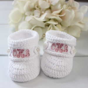 White knitted baby booties with monogrammed initials