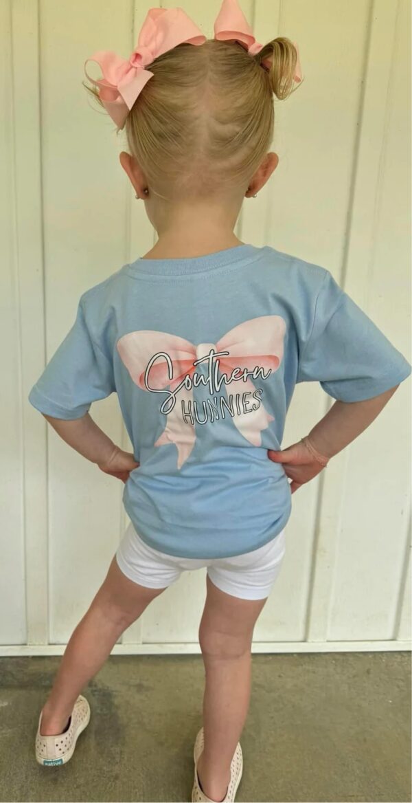 Child wearing Southern Hunnies shirt with pink bow.