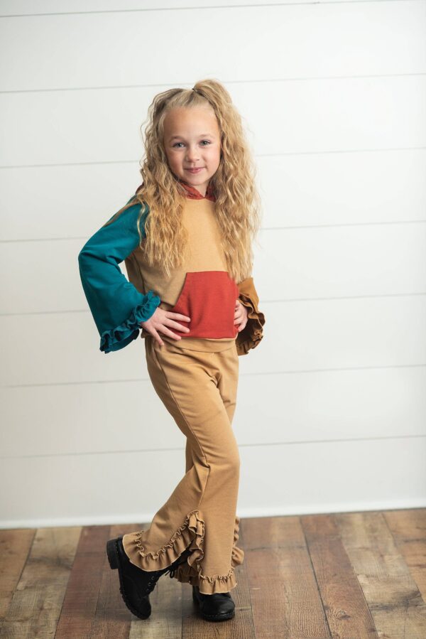oopsie daisy kids rust & brown color block hooded ruffle pocket fall set Child in colorful outfit posing indoors.
