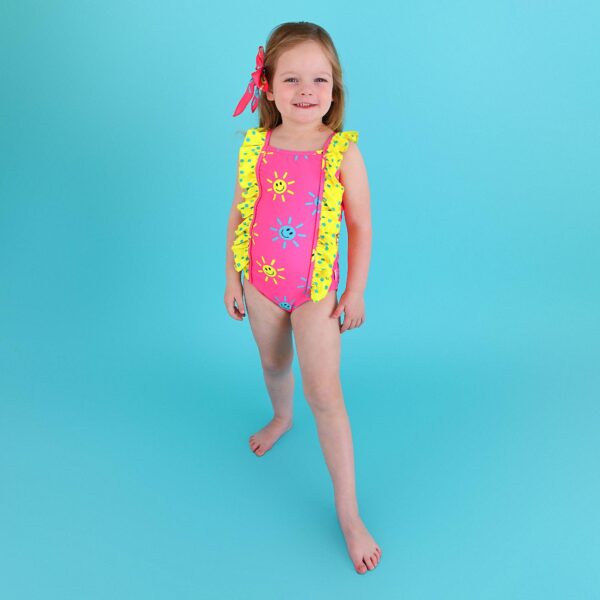 gigi and max brittany smiley face tank one piece swimsuit Child wearing colorful swimsuit with sun patterns.