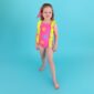 Child wearing colorful swimsuit with sun patterns.