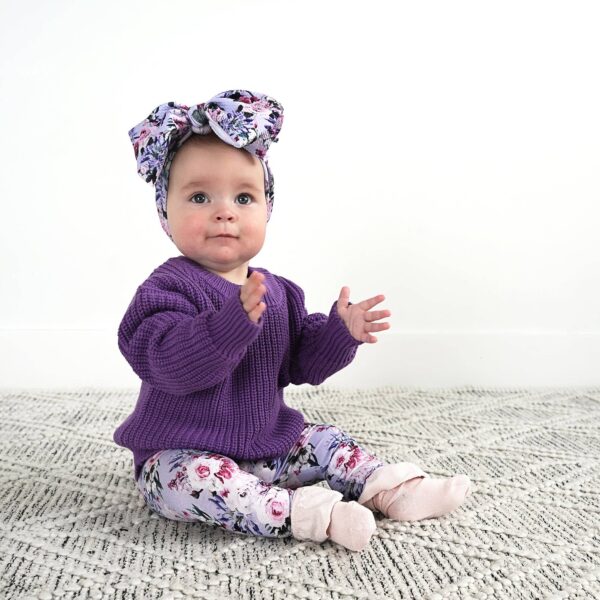 gigi and max emerson legging and sweater set Baby in purple sweater and floral headband sitting.