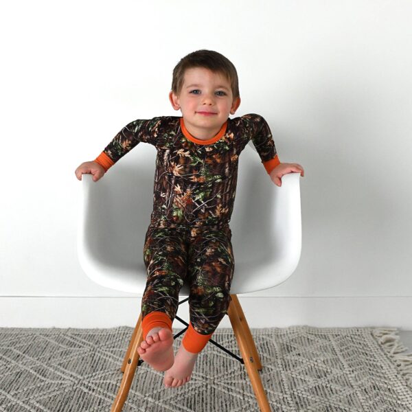 gigi and max hunter camo two piece no button bamboo outfit lounge Child in camouflage pajamas on white chair