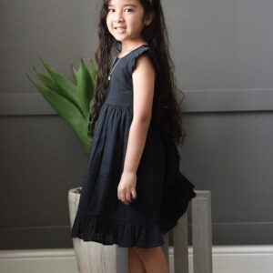 Child in black dress and white headband