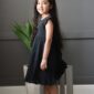 Child in black dress and white headband