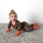 Baby in camo outfit crawling on carpet