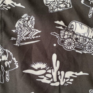 Western-themed fabric with cowboy and wagon illustrations.