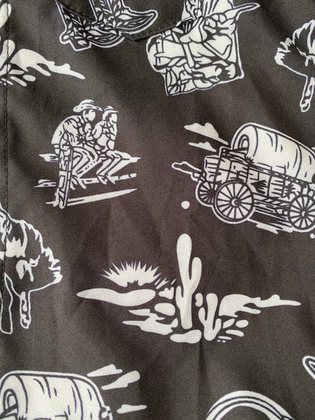 shea baby wild west oneise Western-themed fabric with cowboy and wagon illustrations.