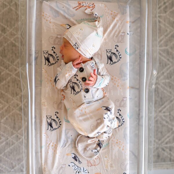 gigi and max bamboo baby gown Newborn in patterned sleep sack on crib mattress.