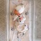 Newborn in patterned sleep sack on crib mattress.