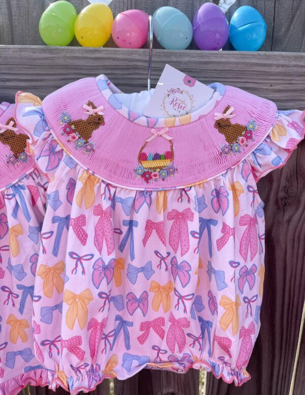 Pink baby dress with bow and rabbit embroidery.