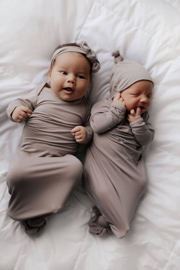 three little tots harbor mist taupe knotted gown Two smiling babies in matching beige outfits.