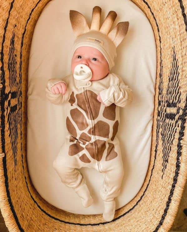 itzy ritzy sweetie soother™ pacifier sets (2 pack): pink bows Baby in giraffe costume with pacifier, straw basket.