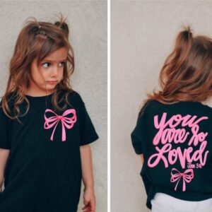 Girl wearing T-shirt with bow and motivational text.