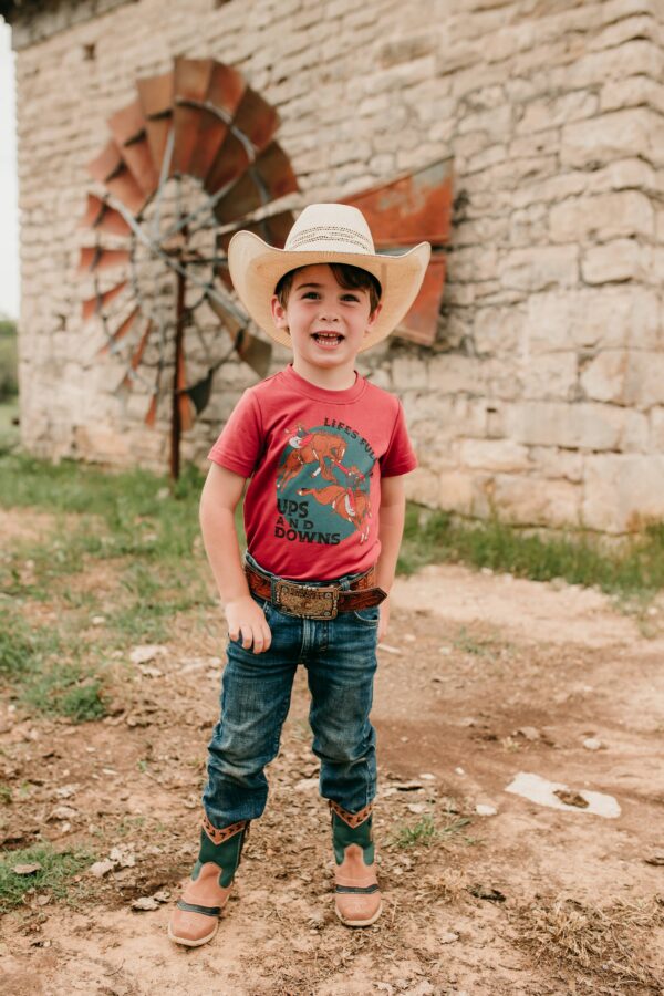 Child in cowboy hat smiling outdoors