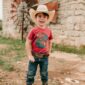 Child in cowboy hat smiling outdoors