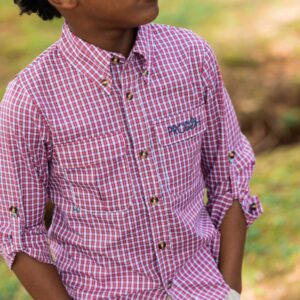 Boy in red plaid shirt outdoors looking sideways.