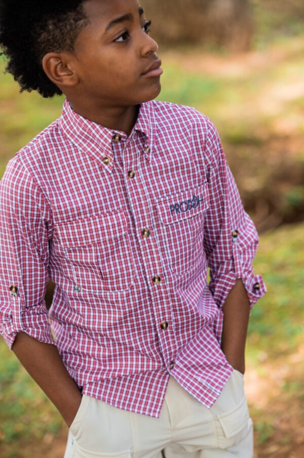 prodoh founder's fishing shirt Boy in red plaid shirt outdoors looking sideways.