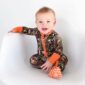 Baby in camouflage onesie sitting on chair